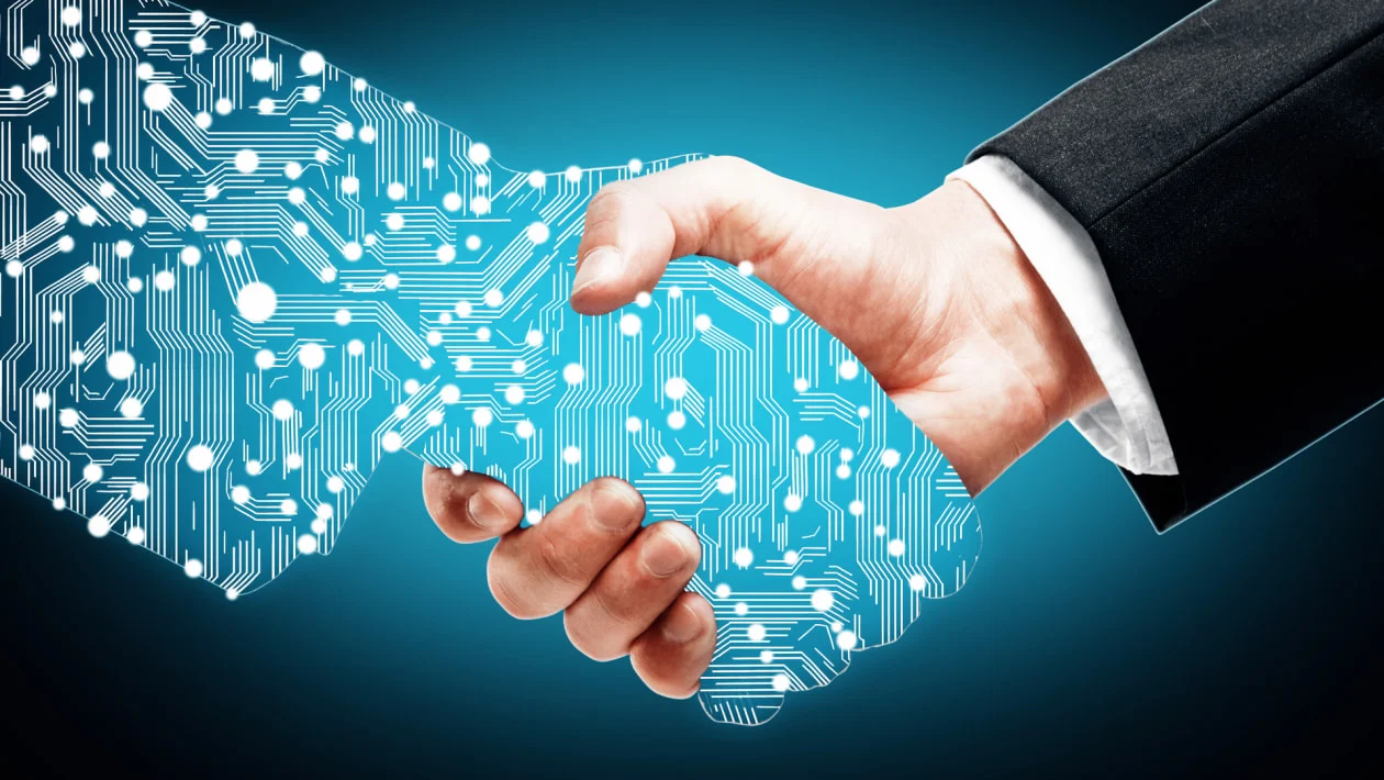 a digital hand shaking a human hand 